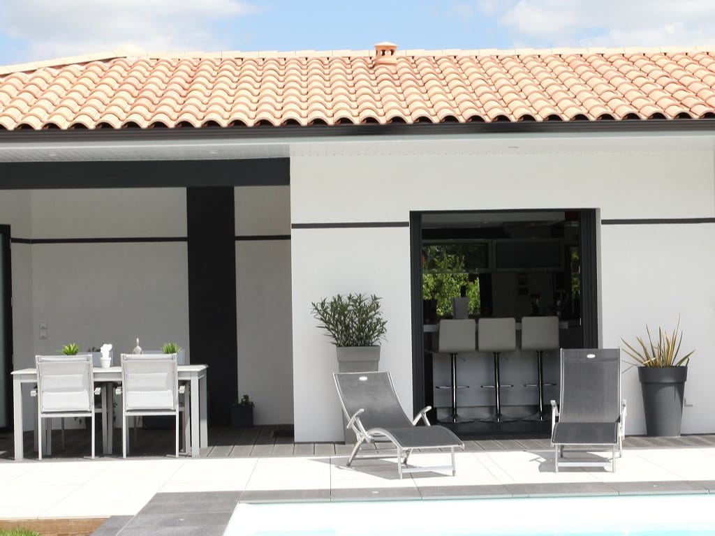 Maison moderne avec terrasse, piscine et mobilier de jardin design