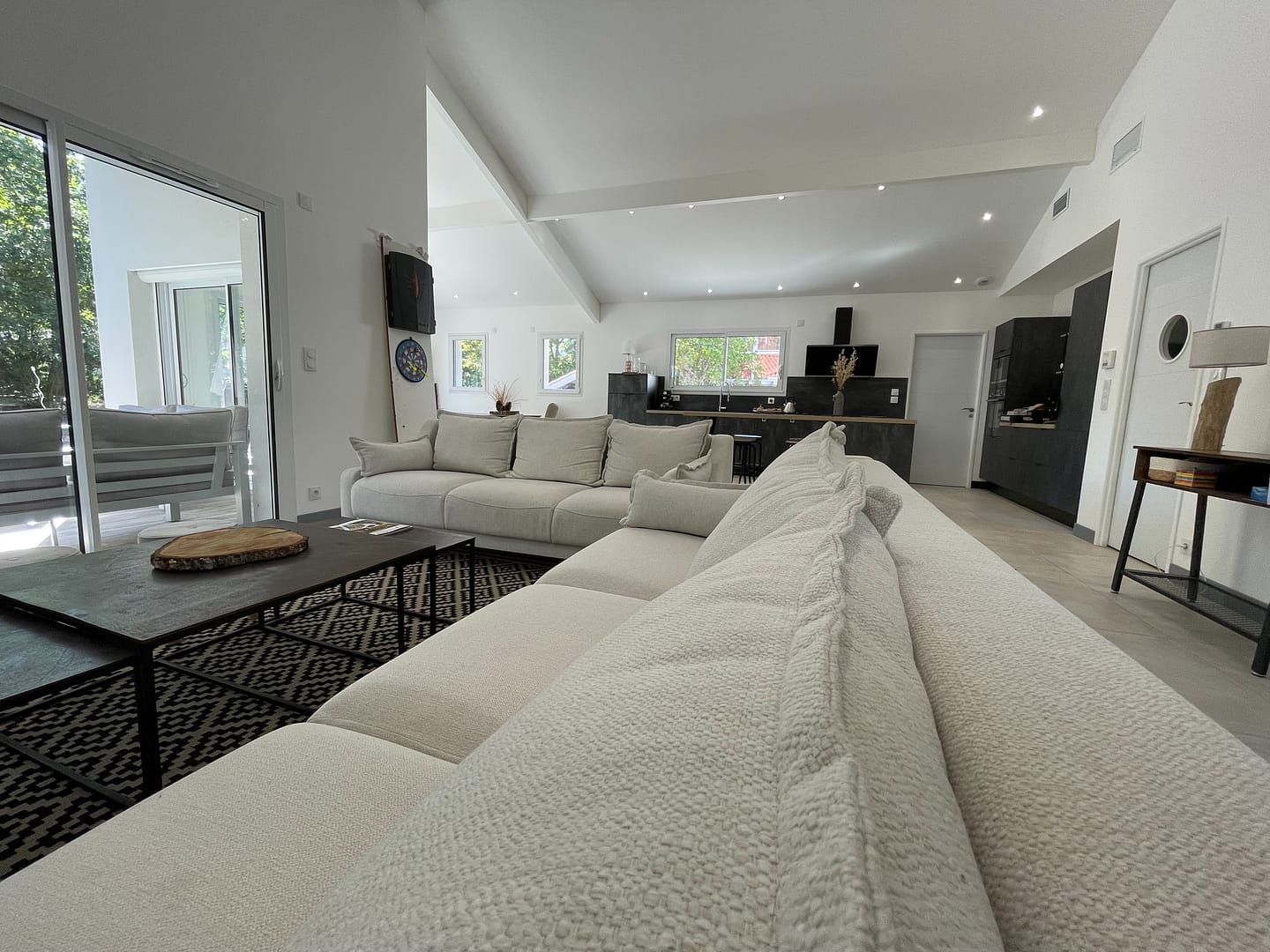 Grand salon moderne avec canapé, cuisine ouverte
