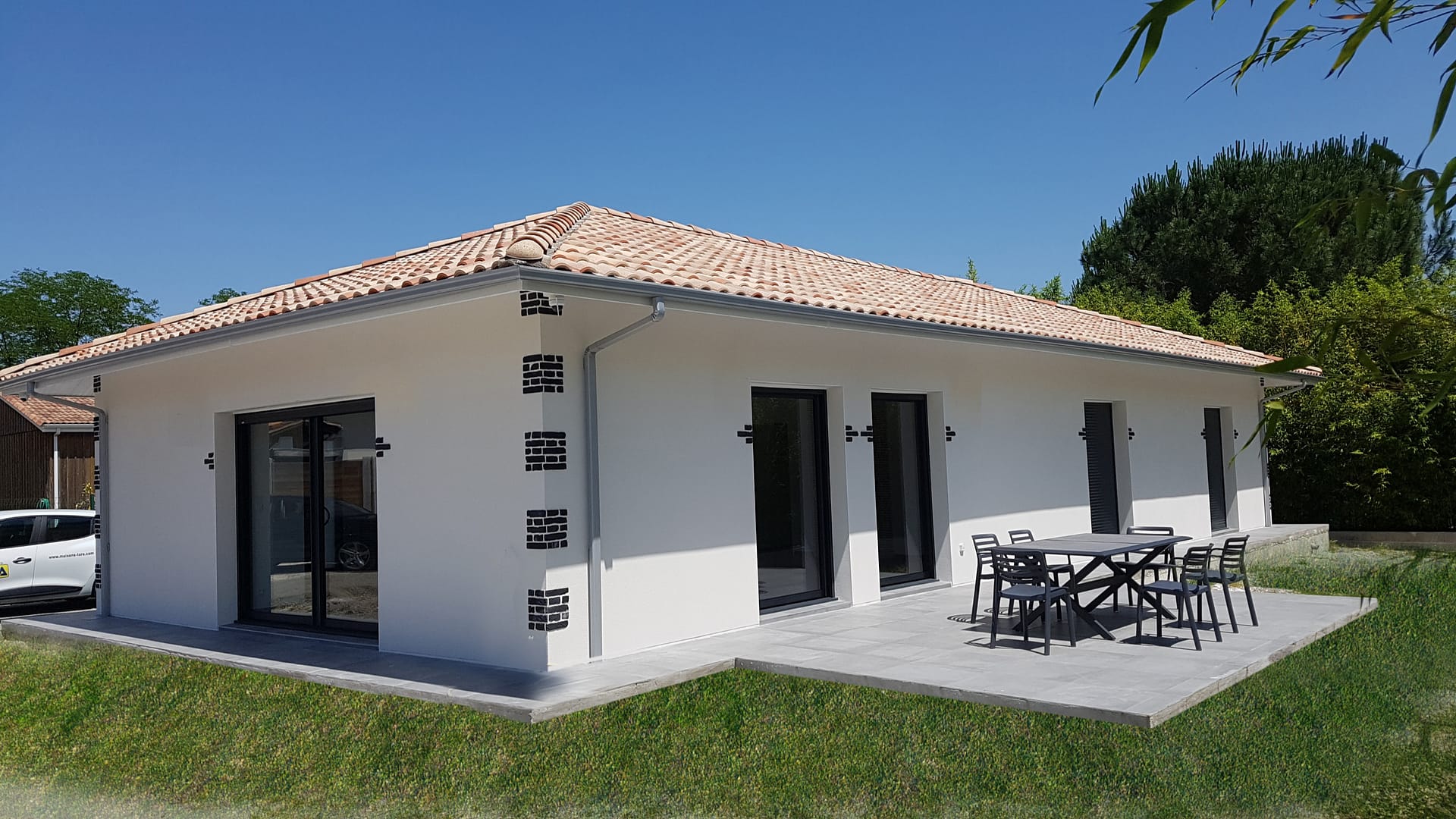 Maison moderne avec terrasse et jardin ensoleillé