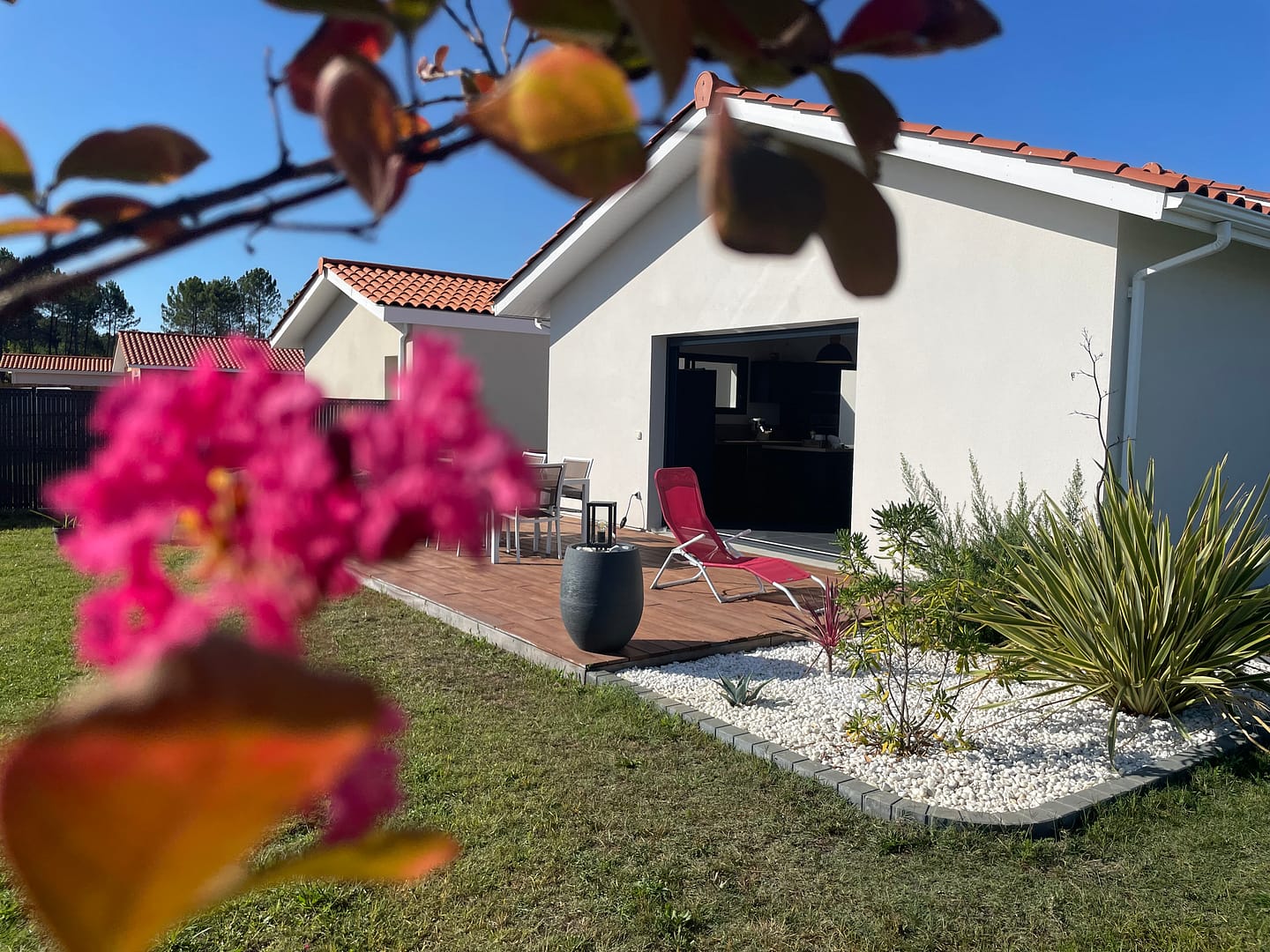 Maison moderne avec jardin fleuri et terrasse ensoleillée