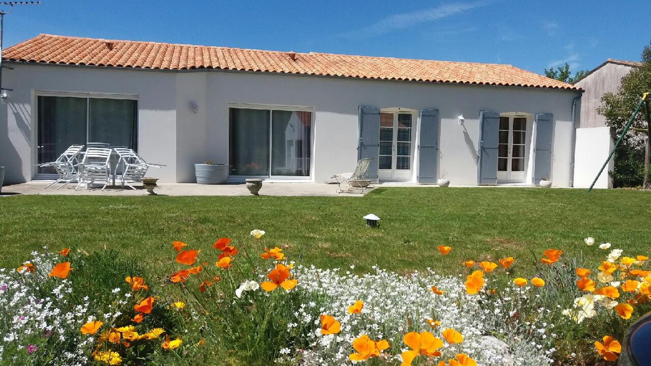 Maison traditionnelle avec jardin fleuri et terrasse ensoleillée