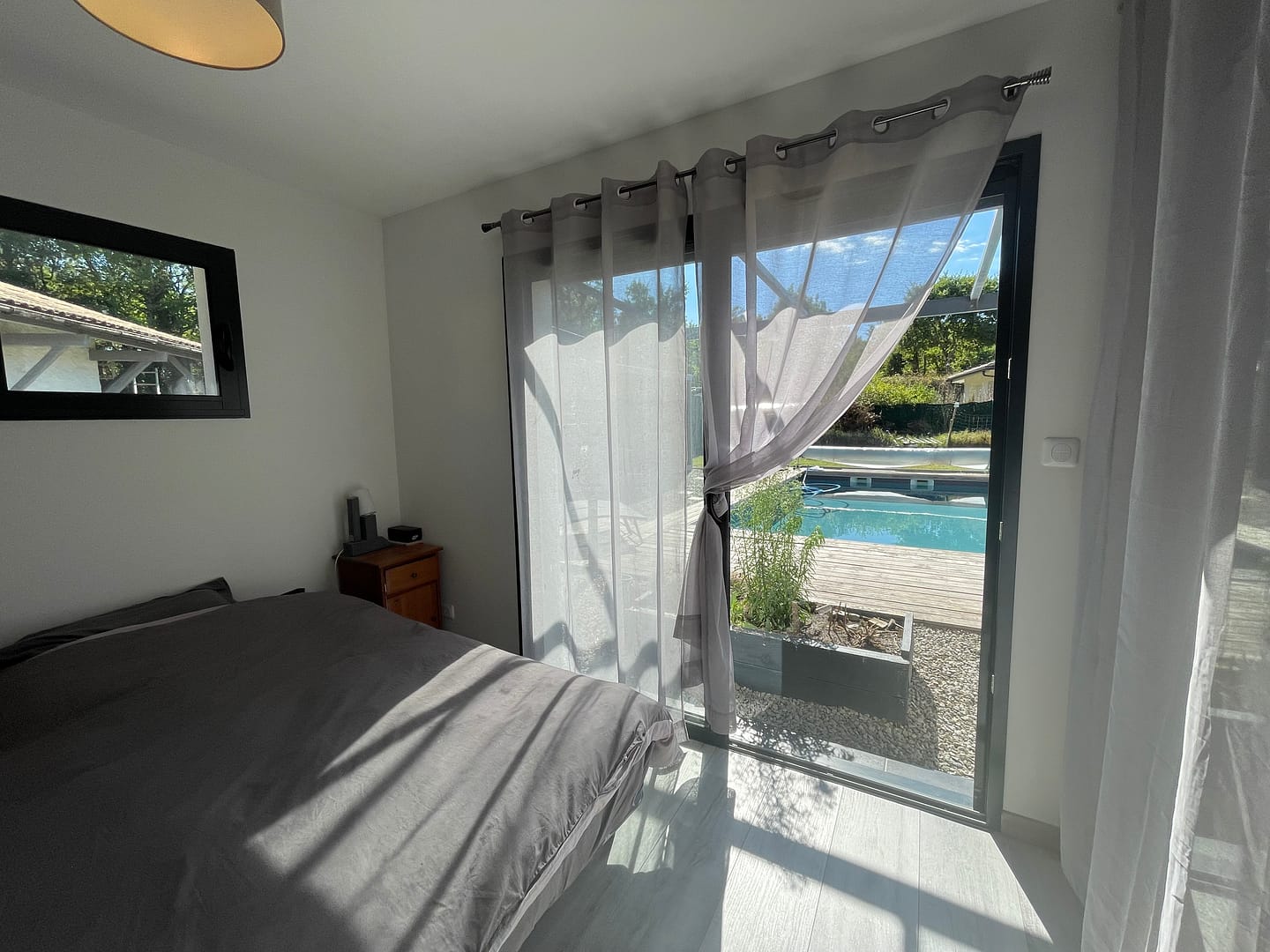 Chambre moderne lumineuse avec vue sur piscine