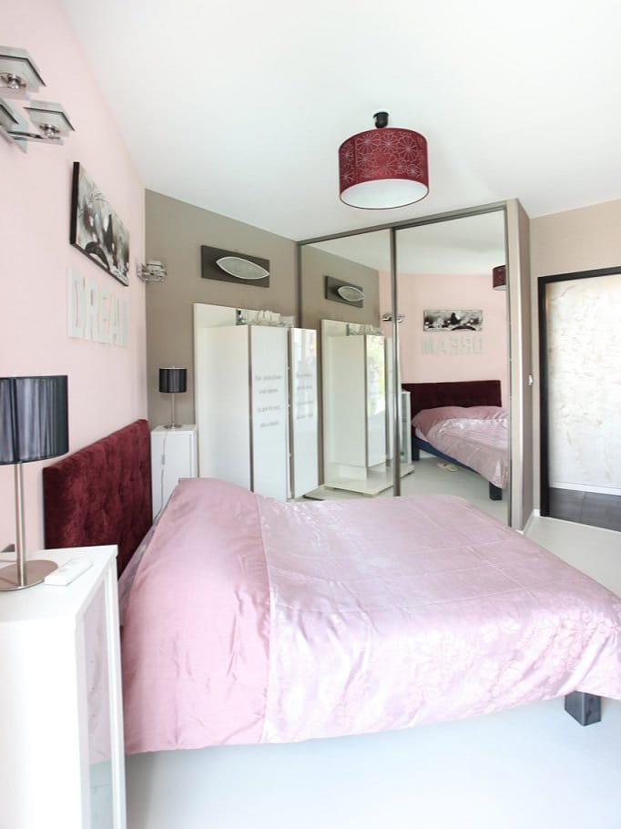 Chambre élégante rose avec miroir et déco moderne